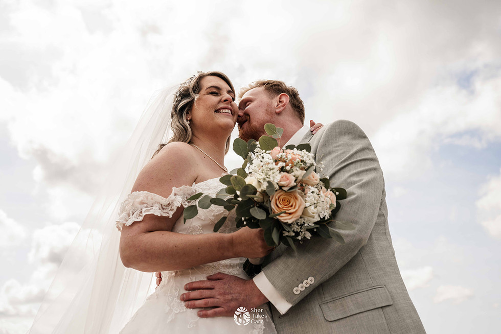 Bruidegom geeft zijn aanstaande vrouw, de bruid, een kus in haar nek