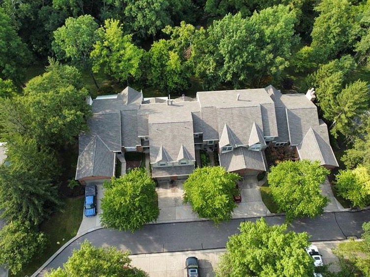 Aerial view of a multi-unit commercial housing complex in Sharonville, Ohio, with new roofing installed by Front Line Roofing, surrounded by lush greenery and a serene neighborhood.