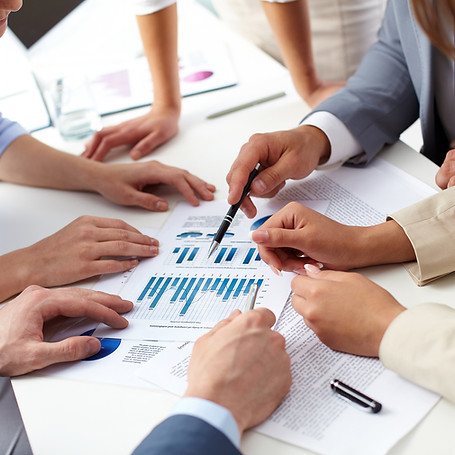 Hands of business professionals point at a financial chart