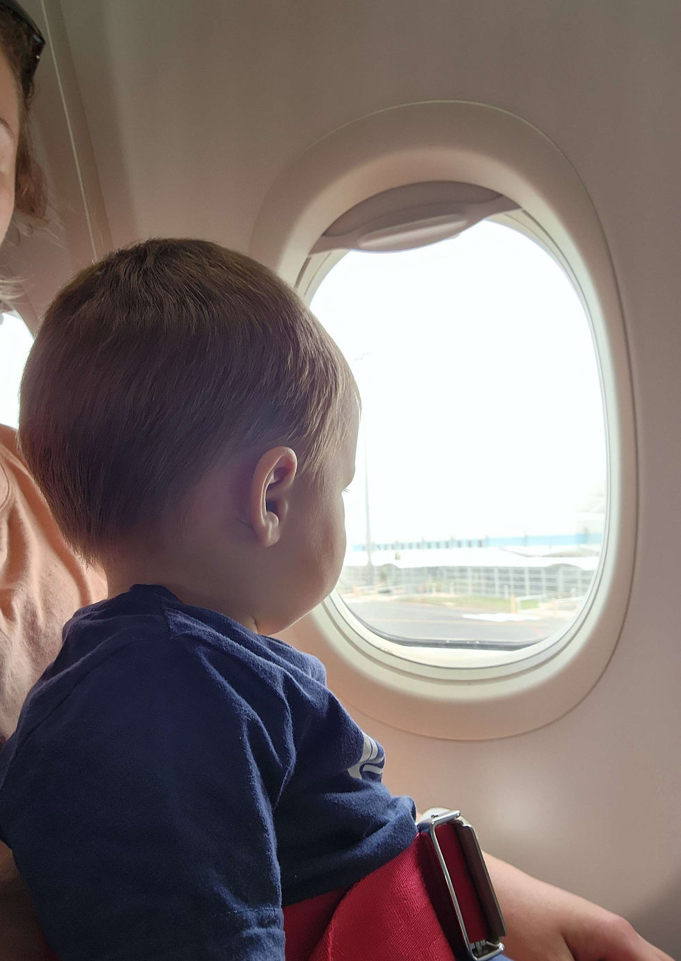 toddler on plane looking out window