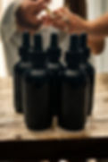 Thumbnail: Five black dropper bottles on a wooden table, with hands applying liquid.