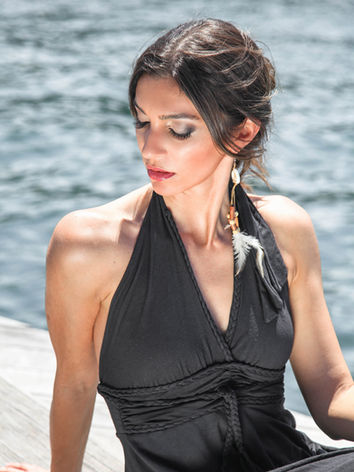 Woman in black halter dress by the sea
