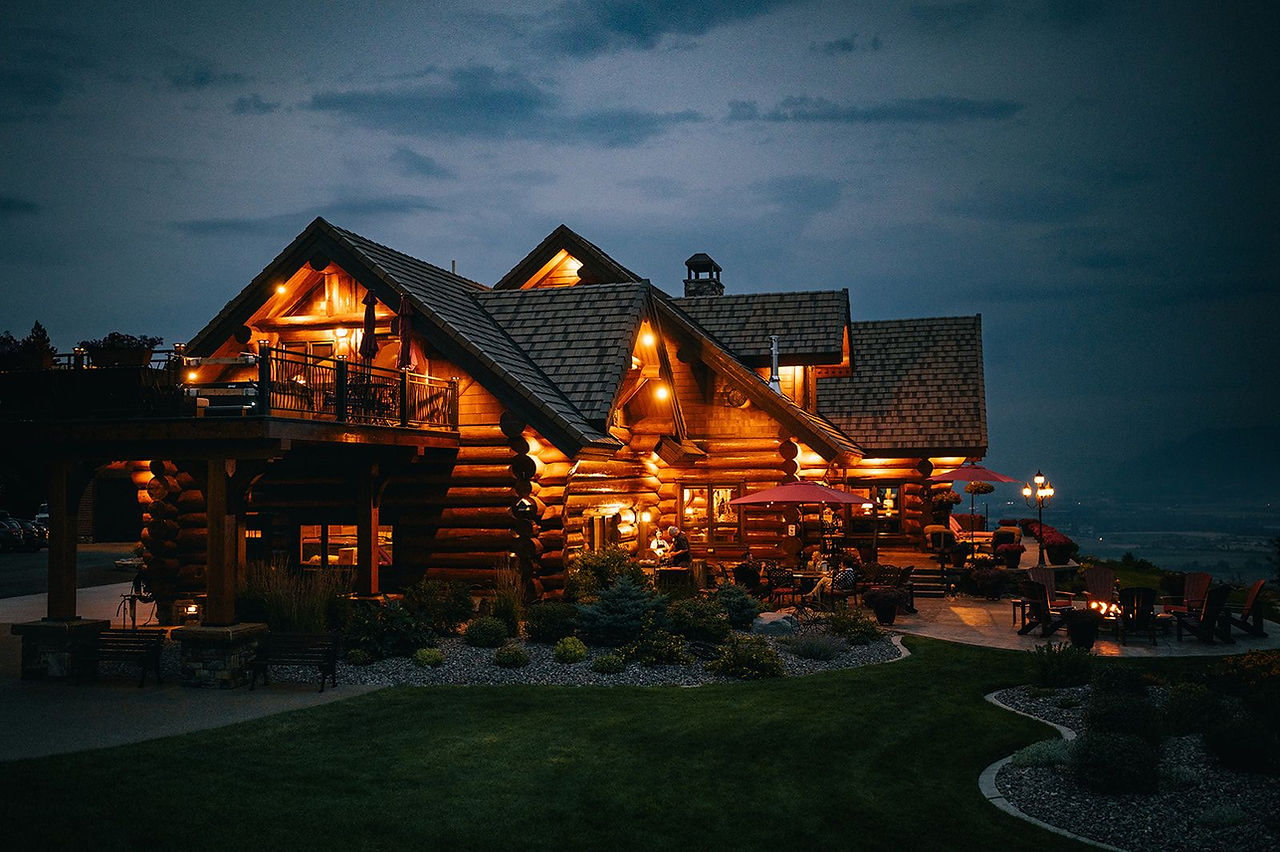 The log lodge glowing with warm light at dusk