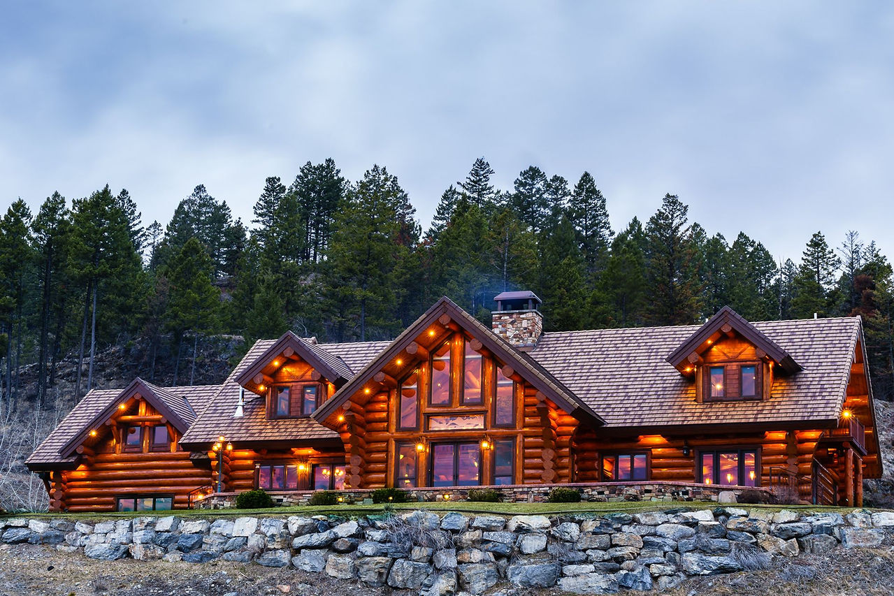 The log lodge with its lights on beneath the pines