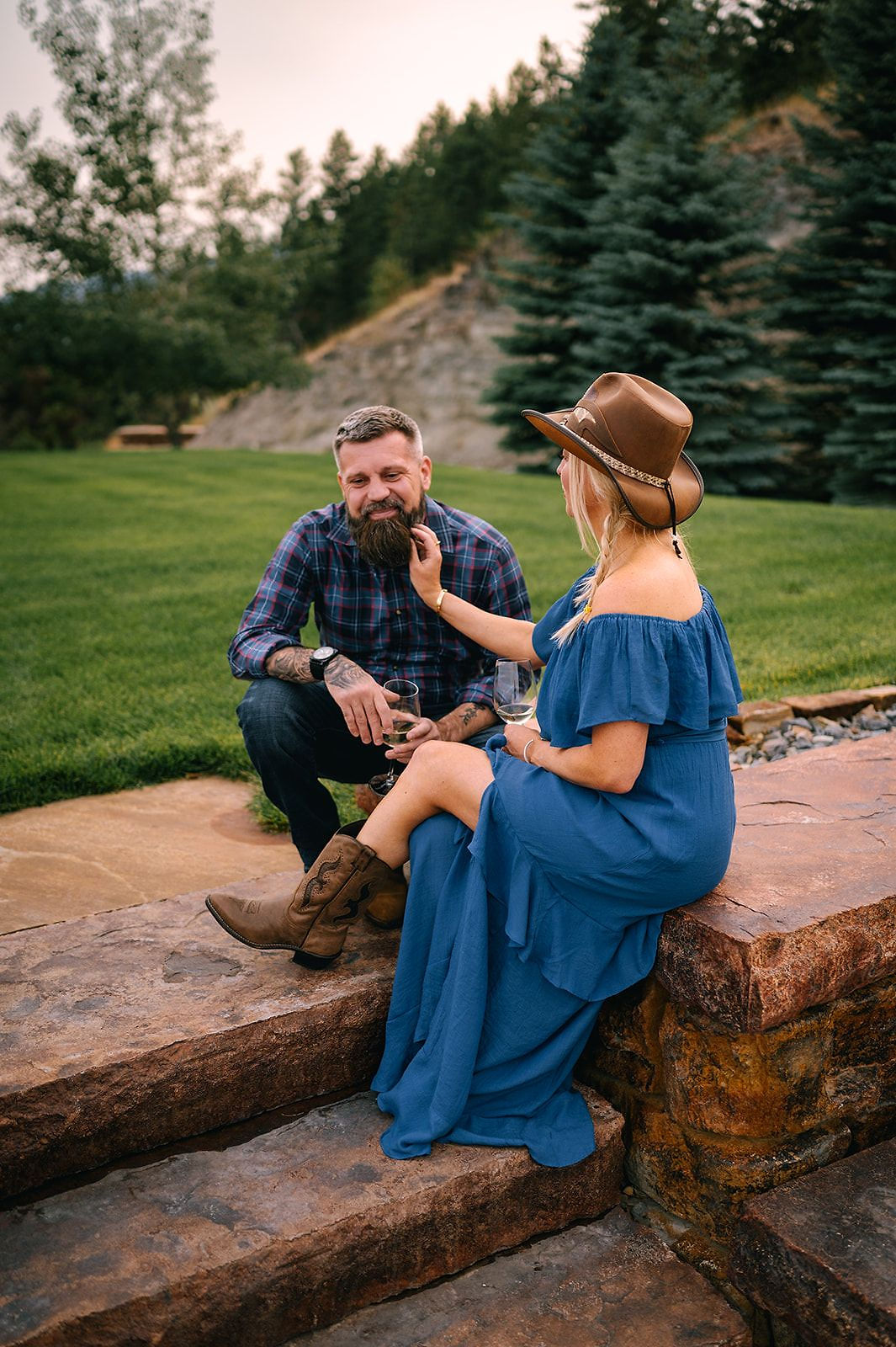 A couple sitting together on a rock on the lawn