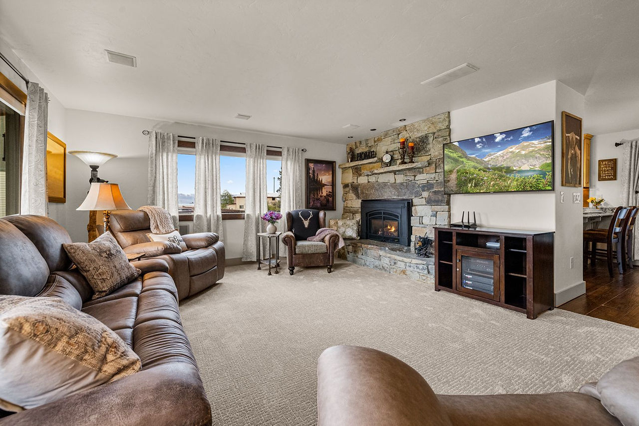 Somers House: living room with sectional sofa, stone fireplace and big windows