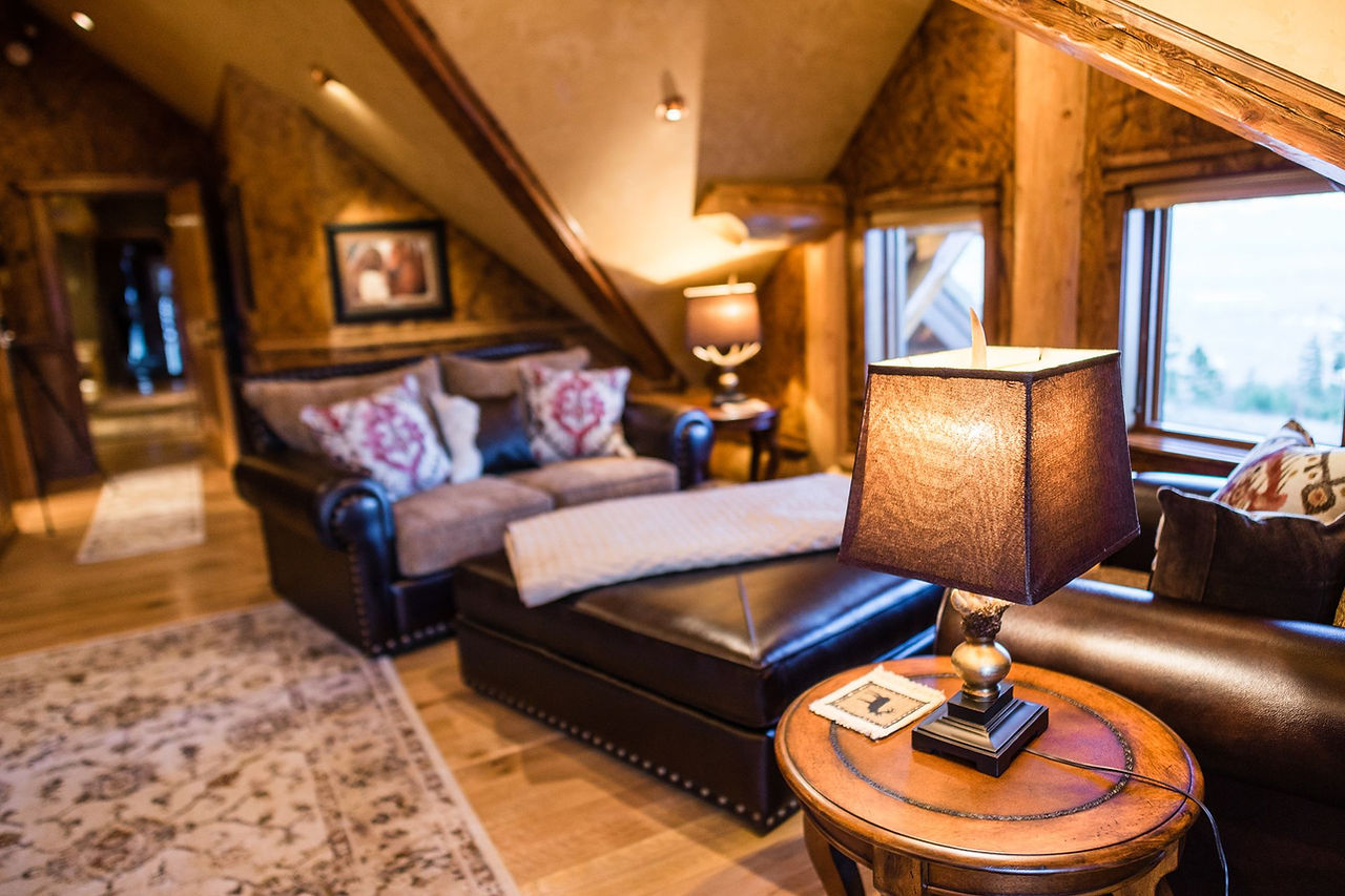 Leather sofa and reading lamp beside a window in the Yellowstone Suite