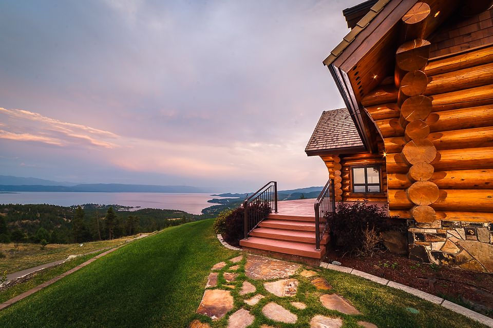 Log porch at sunset overlooking the hillside and Flathead Lake