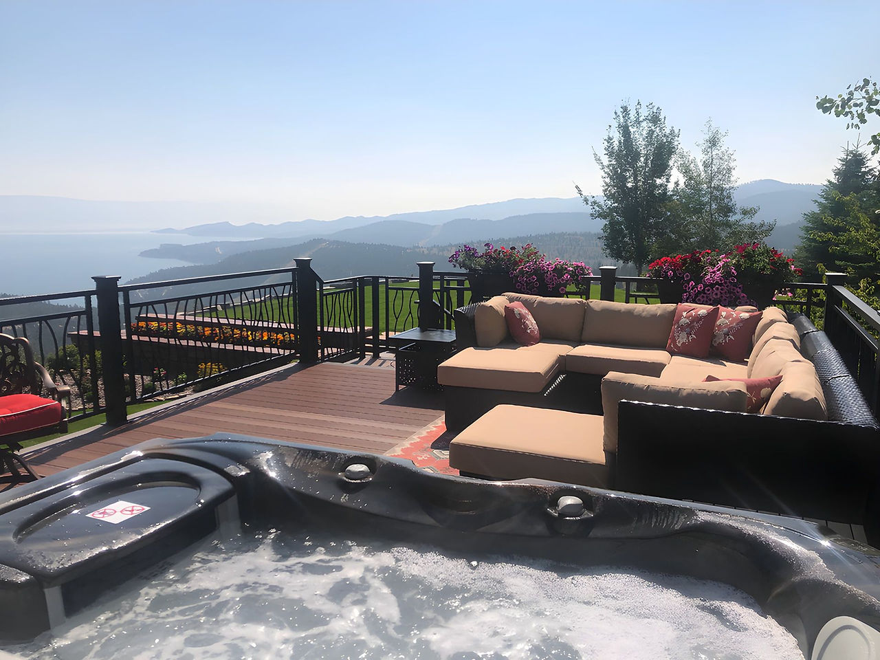 A private hot tub and deck seating overlooking the lake and the valley