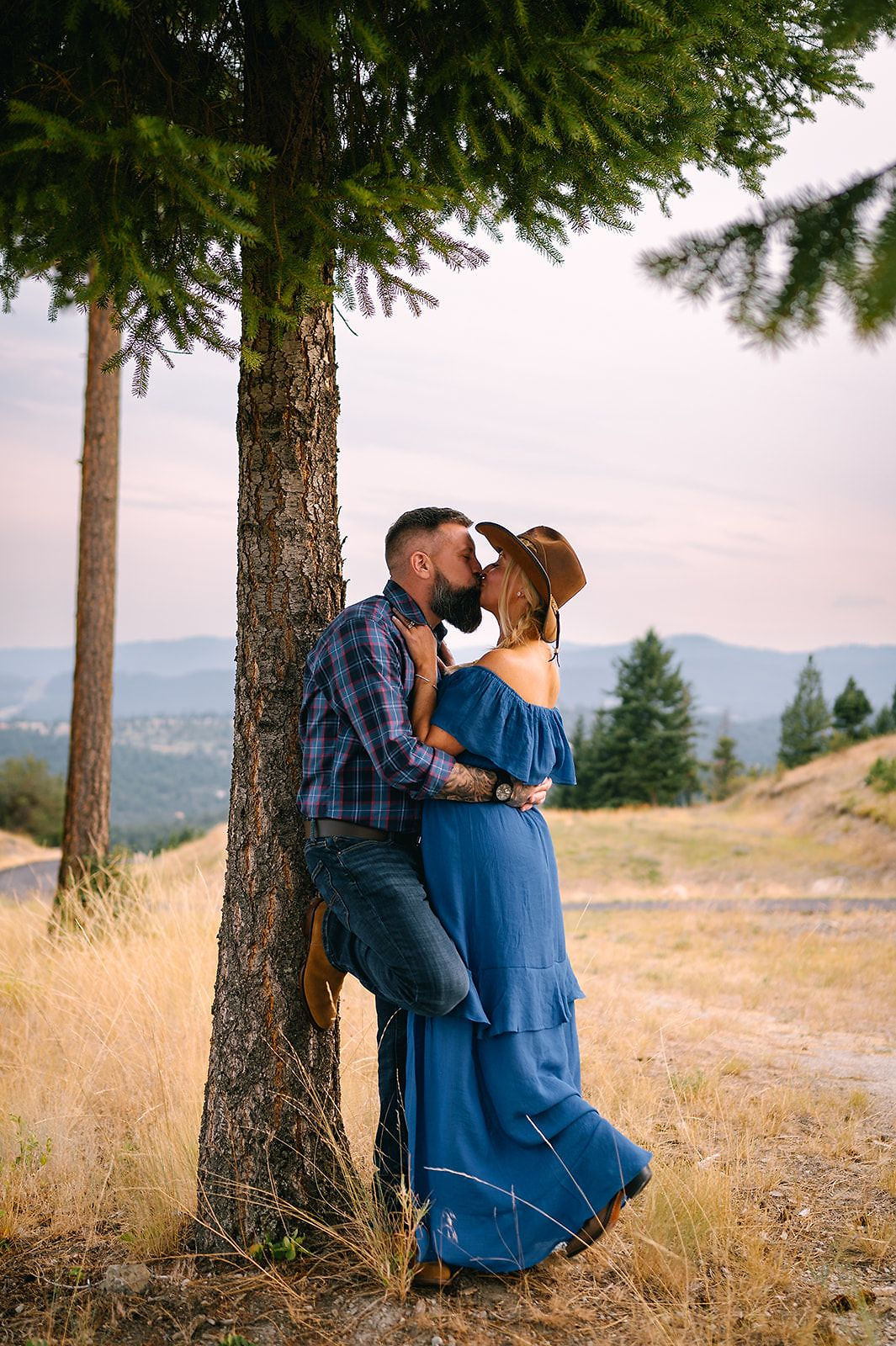 A couple embracing by a tree in the evening light