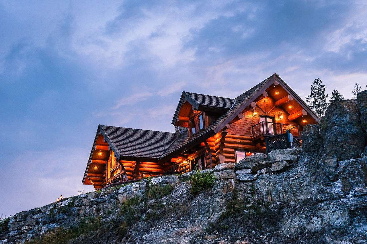 The lodge perched on a rocky hillside at dusk