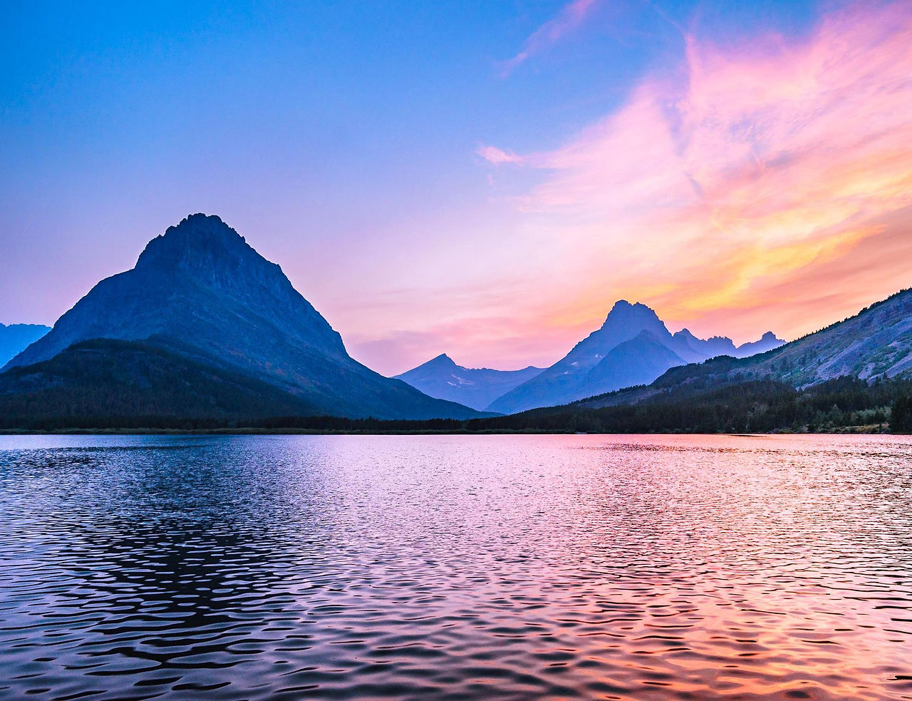 Mountain lake under a pink and purple sky
