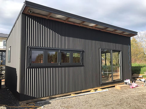 Modern custom cabin with cladding and large windows for outdoor connection