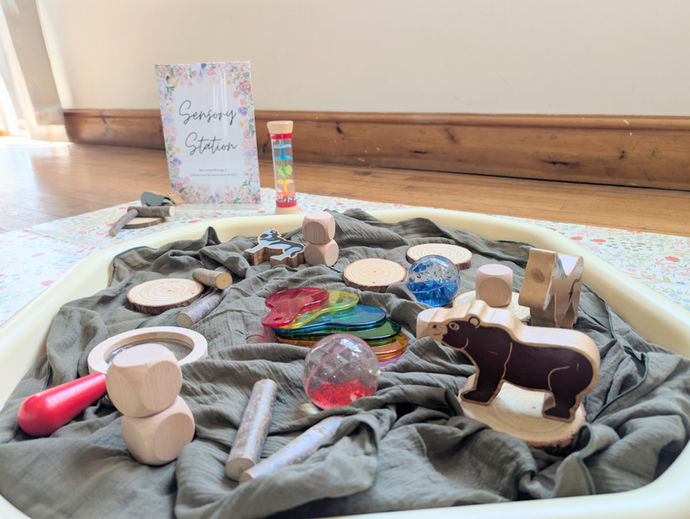 A sensory tuff tray hire for a toddler's party. This messy play station is filled with sand, wooden scoops, bowls, and blocks to encourage imaginative play.