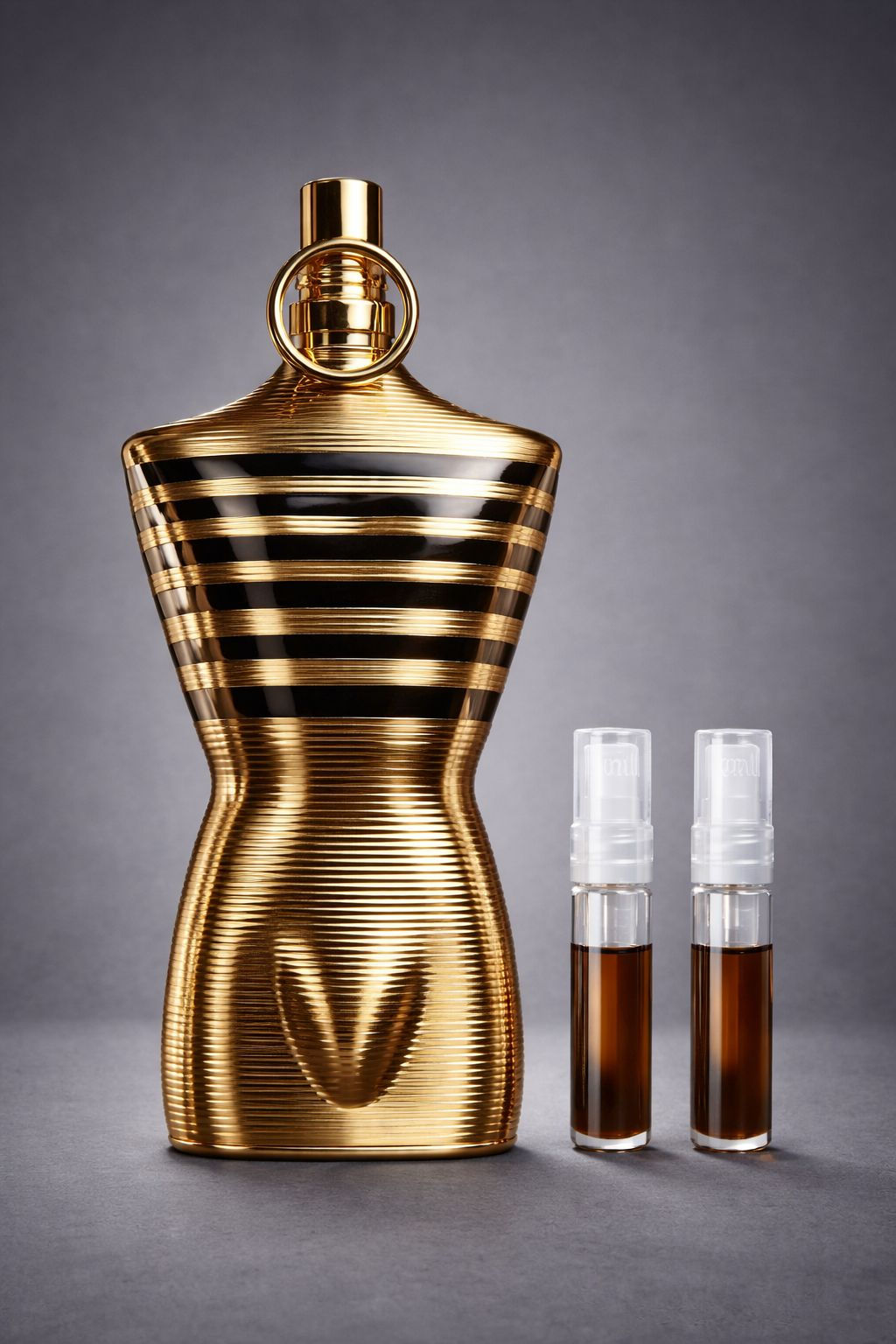 Frasco Le Male Elixir junto a dos decants de perfume.