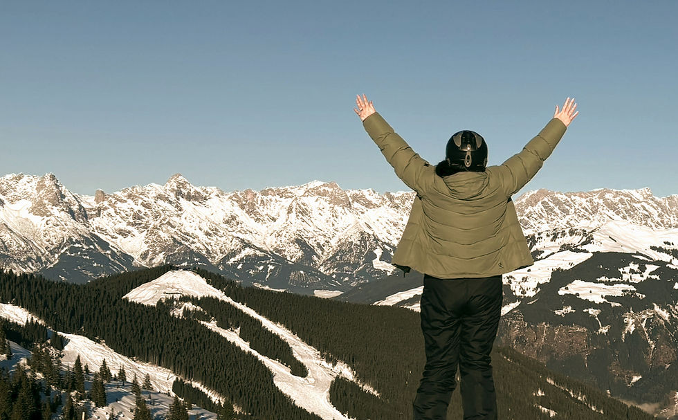 Back of person facing mountain range having reached the summit