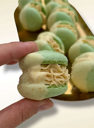 Tray of colourful macarons with a hand holding one – handcrafted desserts for corporate events and candy bars by Andreea Molo