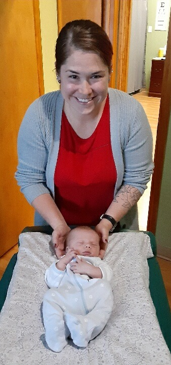 Dr. Erdmann adjusting a new born baby under 1 month old.