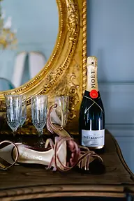 Bodegón con los zapatos de novia, la botella de champán y las copas frente a un espejo dorado en una de las estancias del Marquesado de Casa Colorada.