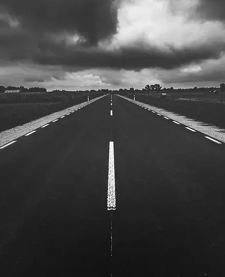 Photo of highway with storm clouds in the distance