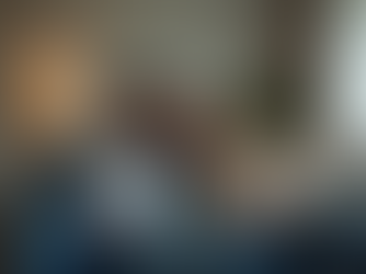 Eye-level view of a couple sitting apart on a couch, showing emotional distance