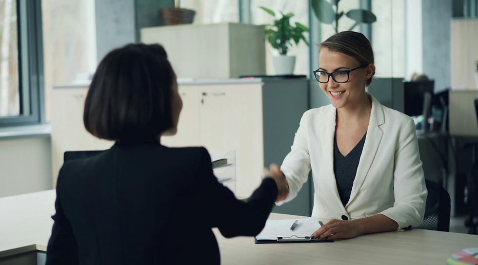 Two business women shaking hands.
