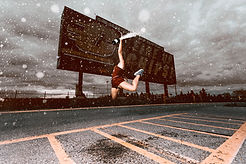A Central Michigan University dancer jumps and sprays champagne in front of the Kelly-Shorts Stadium "Fire Up Chips!" sign.
