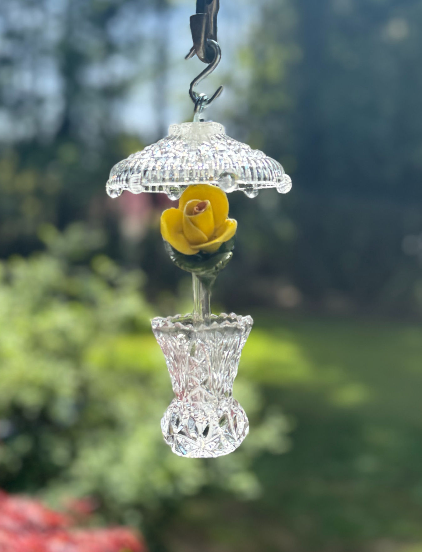Hanging clear glass ornament with a golden yellow rose