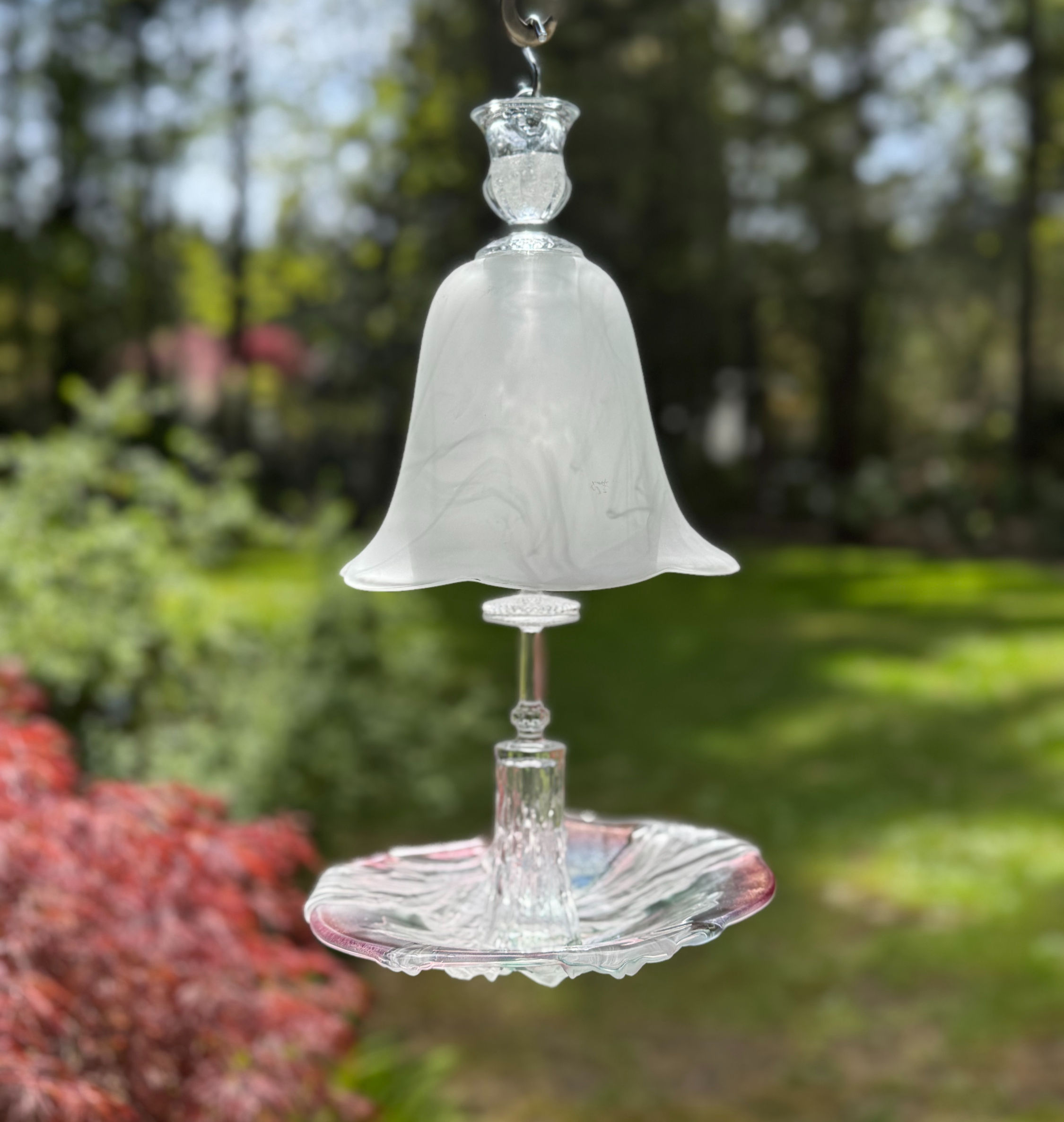 Frosted glass White Whisper Bell hanging outdoors