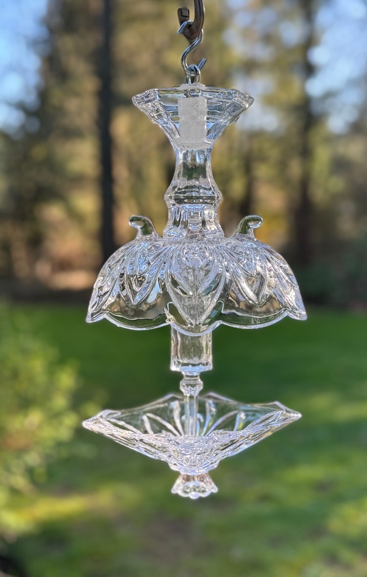 Two-tiered cut-glass bird feeder with decorative patterns