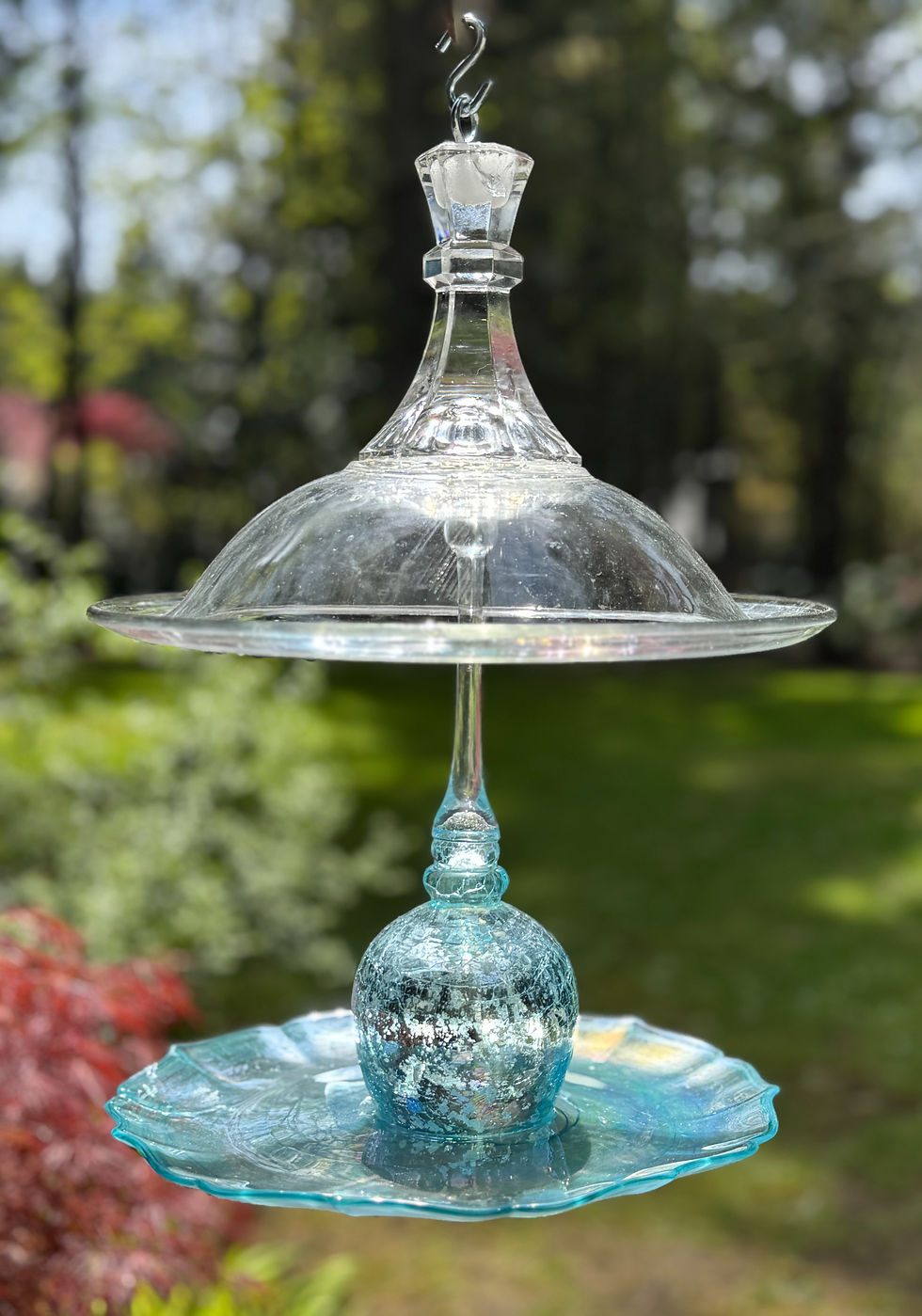 Decorative glass bird feeder hanging outdoors