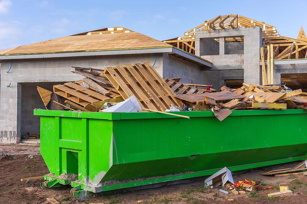 Dumpster full of wooden pallets, boards, and other waste on the site of a single-family ho