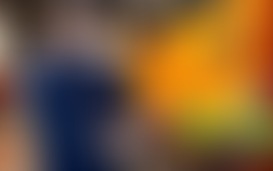 Mechanic in a blue uniform writes on a clipboard beside an orange truck in a garage. A pot of gold, rainbow, and clovers overlay the image.