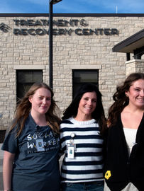3 women stand in front of the Treatment & Recovery Center.