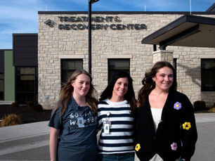 3 women stand in front of the Treatment & Recovery Center.