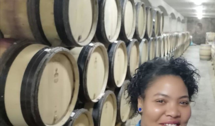 A smiling woman in a wine cellar