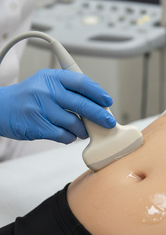 female ultrasound sonographer's hand with ultrasound probe imaging a female stomach.jpg
