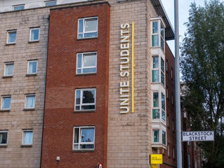 a tall brick building with a sign on the side of it