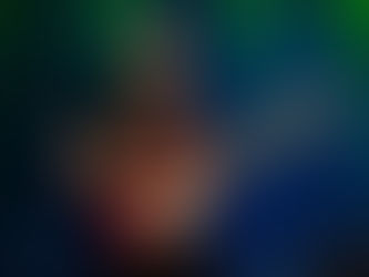 Elderly man passionately plays a red electric guitar on stage with a vivid blue and green curtain backdrop, conveying a lively mood.