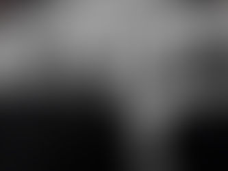 Four men in sunglasses stand against a weathered wall. One wears a hat with "Deus" text. The mood is serious and monochrome.