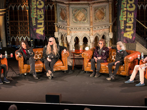 Five people sit on stage in a panel discussion, with "The Reverend Alice Cooper" banner behind them. Ornate backdrop and casual setting.
