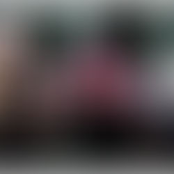 Three people in fantasy costumes with dramatic expressions in a forest. One has red wings, another wears fur, all in dark outfits.