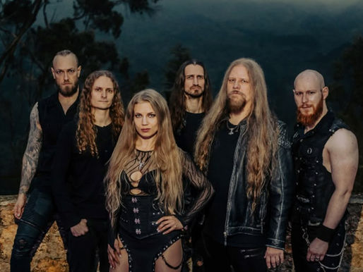 Six people with long hair and leather outfits pose confidently outdoors against a foggy forest background, creating a moody atmosphere.