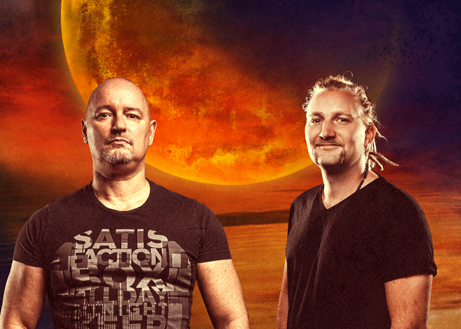 Two men pose before a fiery orange moonlit sky; the left shirt shows SATISFACTION in bold text.