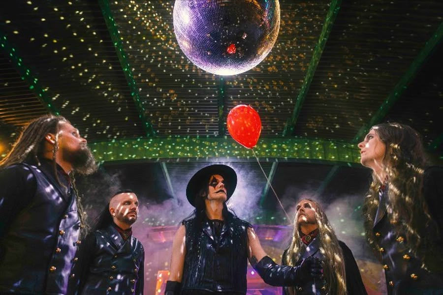 Five people in black outfits stand under a disco ball in a smoky room, gazing at a floating red balloon. Mood is mysterious.