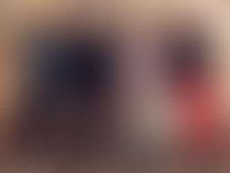 Five people stand on rocky ground, wearing casual and colorful attire. They are smiling in front of a beige, paneled wall.