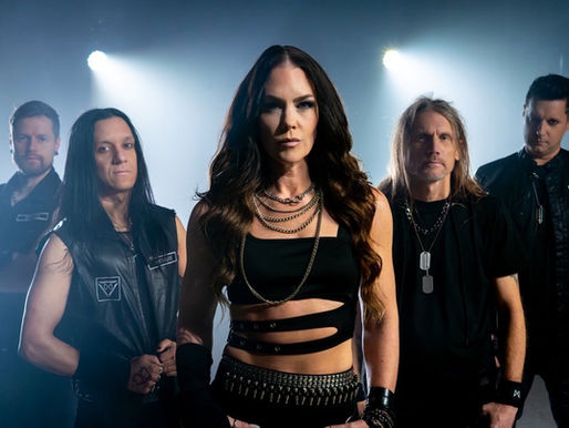 Five people in black clothing stand confidently under bright stage lights, exuding a bold and intense mood. Chains and patterns visible.
