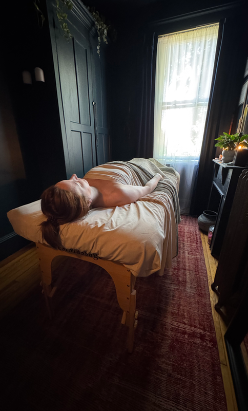 Client relaxing during a massage therapy session at Shire Wellness in Edgewater, New Jersey in a private wellness studio.