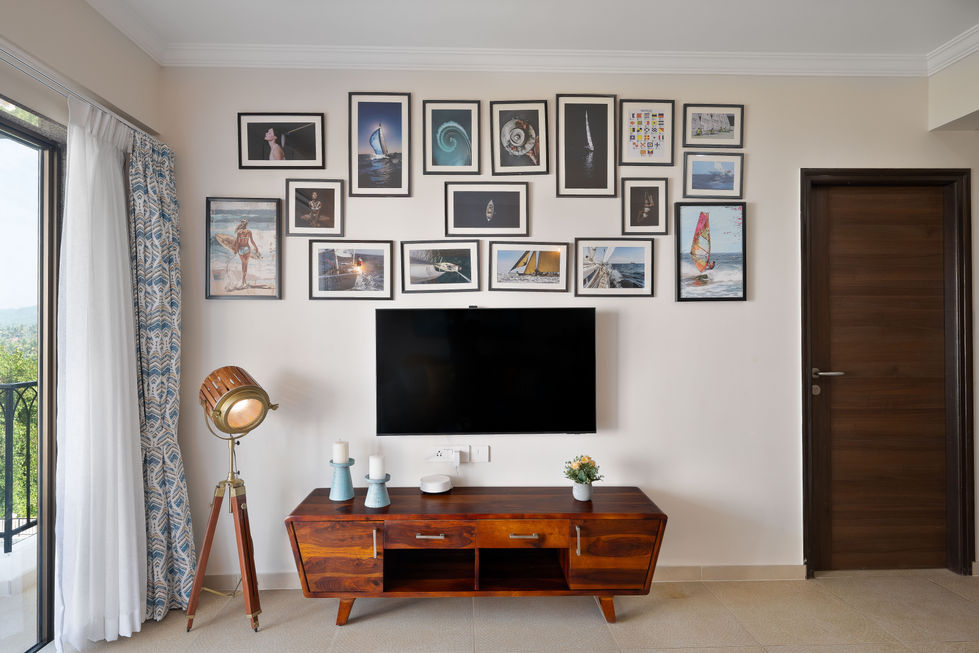 Gallery wall above TV with eclectic framed art.