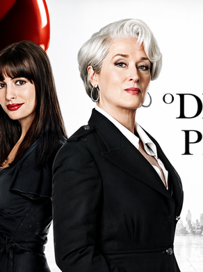 Pôster do filme O Diabo Veste Prada com Anne Hathaway e Meryl Streep em frente a um salto alto vermelho, símbolo da indústria da moda